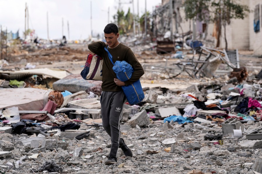 A Palestinian man collects his belongings southeast of the Gaza City on Tuesday, Nov. 28, 2023. on the fifth day of the temporary ceasefire between Hamas and Israel. (AP Photo/Adel Hana)