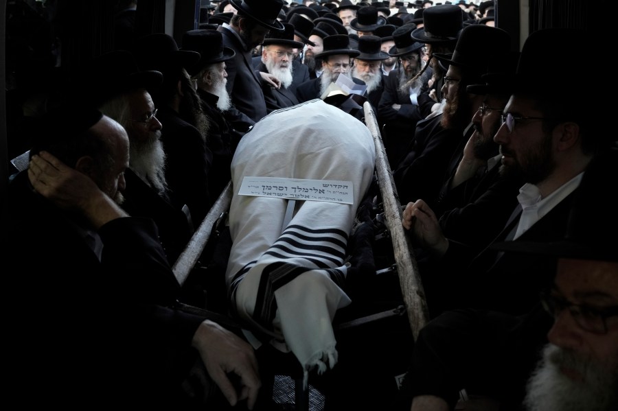 Ultra-Orthodox Jewish men gather around the body of Rabbi Elimelech Wasserman during his funeral in Jerusalem, Thursday, Nov. 30, 2023. Wasserman and at least two other people were killed and several others wounded in a shooting attack in Jerusalem carried out by a pair of Palestinian gunmen that the Hamas militant group claimed as members. Police said the two attackers from east Jerusalem were killed. (AP Photo/Leo Correa)