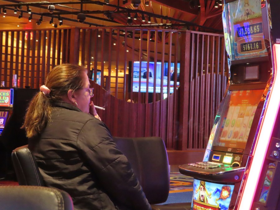 A gambler smokes while playing a slot machine at the Ocean Casino Resort on Wednesday, Nov. 29, 2023, in Atlantic City, N.J. On Thursday, Nov. 30, a bill to ban smoking in Atlantic City's nine casinos was not acted upon following a hearing that was widely expected to start the measure on its way to approval after nearly three years of inaction. (AP Photo/Wayne Parry)