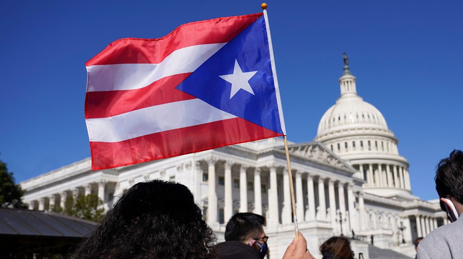 A Puerto Rican flag is waved in a crowd on Capitol Hill.