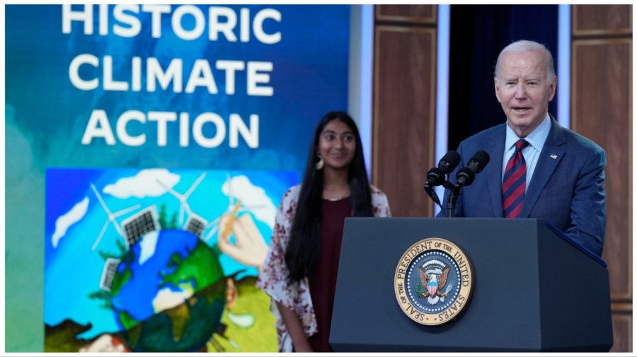 President Joe Biden speaks in the South Court Auditorium on the White House complex in Washington, Tuesday, Nov. 14, 2023, about climate change. Ritika Shah, award-winner of the first-ever National Climate Assessment Art x Climate competition, listens at left. (AP Photo/Susan Walsh)