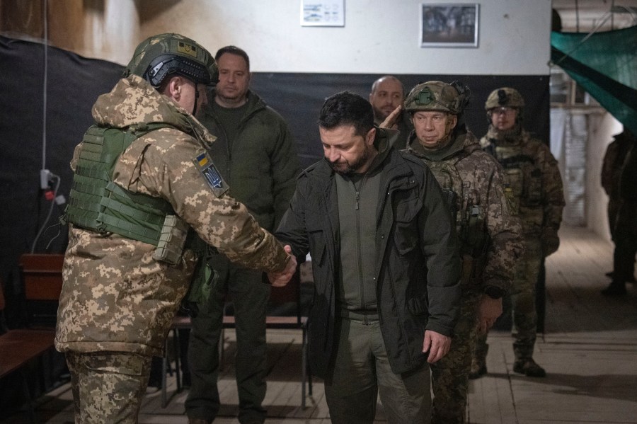 Ukrainian President Volodymyr Zelenskyy shakes hands with a serviceman during his visit to the front-line city of Kupiansk, Kharkiv region, Ukraine, Thursday, Nov. 30, 2023. (AP Photo/Efrem Lukatsky)