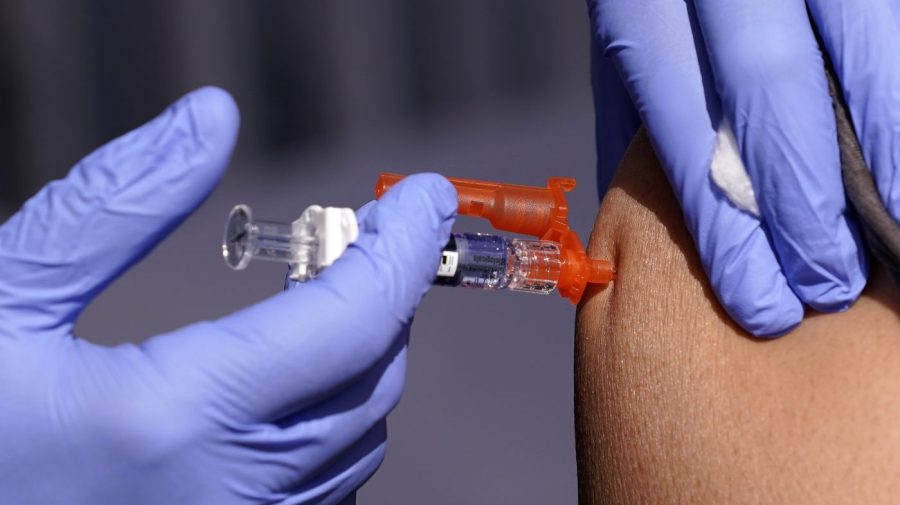 FILE - A patient is given a flu vaccine Friday, Oct. 28, 2022, in Lynwood, Calif. Seasonal flu continues to pick up steam in the U.S. But among respiratory viruses, COVID-19 remains the main cause of hospitalizations and deaths, health officials said Friday, Dec. 1, 2023. (AP Photo/Mark J. Terrill, File)