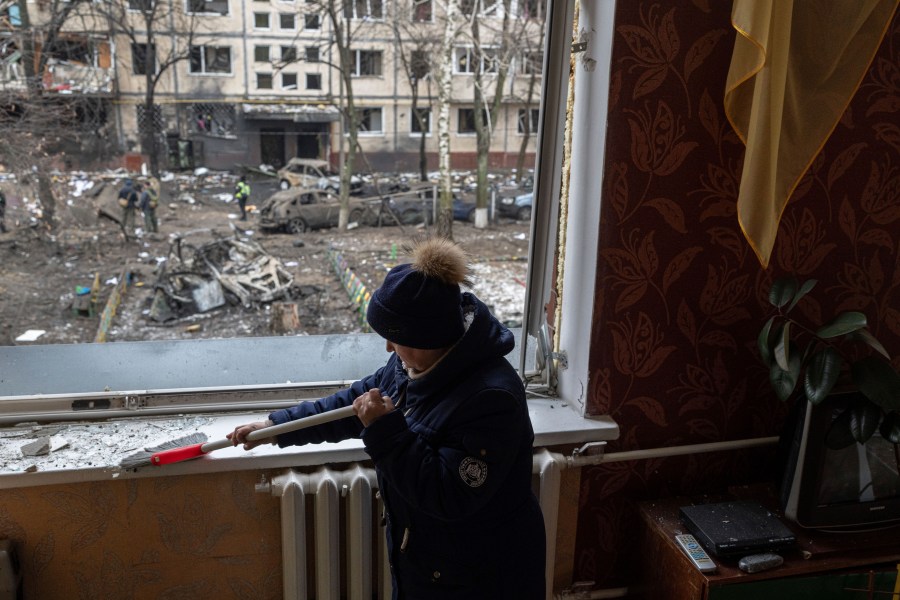 A woman clears broken glass at a kindergarten bedroom after a Russian rocket attack at a residential neighbourhood in Kyiv, Ukraine, Wednesday, Dec. 13, 2023. (AP Photo/Evgeniy Maloletka)