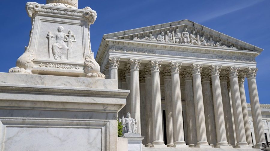 FILE - The U.S. Supreme Court is seen, with a carving of Justice in the foreground, April 19, 2023, in Washington. A Black Ohio woman who miscarried in her bathroom has been charged with abuse of a corpse and awaits grand jury action. Her case has sparked a national firestorm over the plight of pregnant women, especially women of color, following the U.S. Supreme Court’s decision to overturn Roe v. Wade. (AP Photo/Jacquelyn Martin, File)