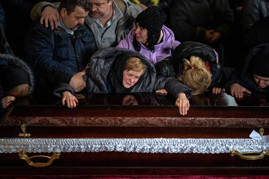 Nadia cries over the coffin of her son Oleg Kunynets, a Ukrainian military servicemen who was killed in the east of the country, during his funeral in Lviv, Ukraine, Tuesday, Feb 7, 2023. (AP Photo/Emilio Morenatti)