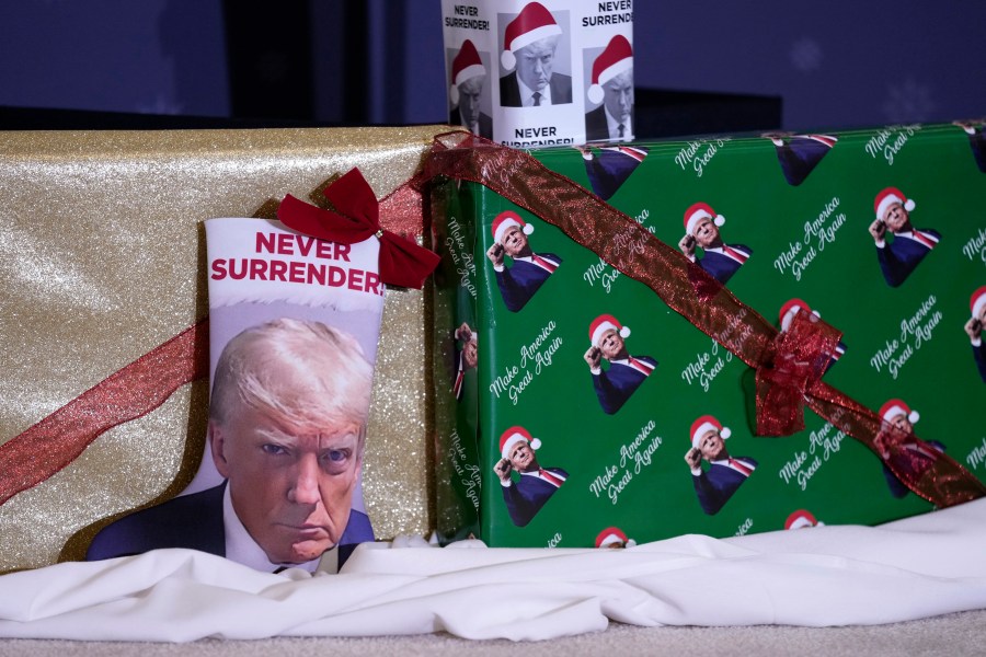 FILE - Christmas gifts are seen on the stage during a former President Donald Trump commit to caucus rally, Tuesday, Dec. 19, 2023, in Waterloo, Iowa. The field of 2024 presidential candidates may have some options for shoppers scrambling for a last-minute holiday gift. As the campaign for the White House kicks into full gear, the contenders are offering an onslaught of holiday-themed merchandise, many of which capture some of the surreal aspects of the 2024 race. (AP Photo/Charlie Neibergall, File)