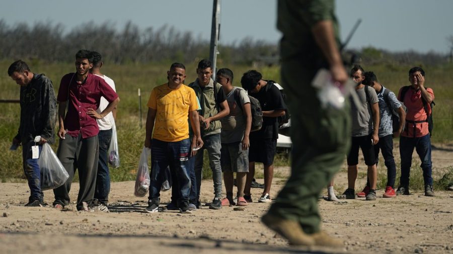 Migrants wait to be processed by the U.S. Customs and Border Patrol after they crossed the Rio Grande and entered the U.S. from Mexico, Thursday, Oct. 19, 2023, in Eagle Pass, Texas. Starting in March, Texas will give police even broader power to arrest migrants while also allowing local judges to order them out of the U.S. under a new law signed by Republican Gov. Greg Abbott. (AP Photo/Eric Gay)