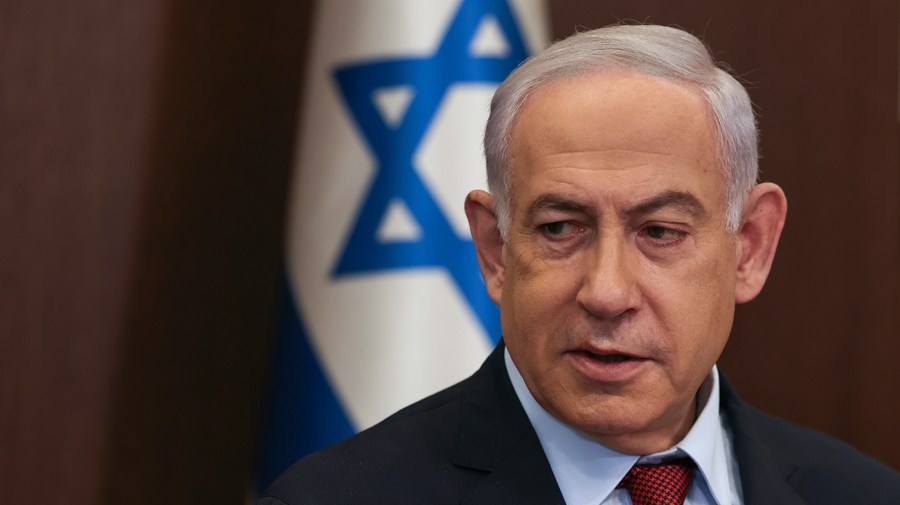 Israeli Prime Minister Benjamin Netanyahu is seen in front of an Israeli flag.