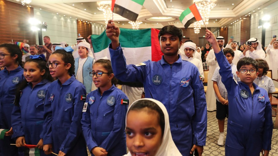 Young supporters of the UAE Space Agency wave national flags and sing the national anthem during a live broadcast of a Russian Soyuz MS-15, that took off from the Baikonur Cosmodrome in Kazakhstan, carrying Emirati Astronaut Hazzaa al-Mansoori and two other astronauts heading to the International Space Station, in Abu Dhabi, United Arab Emirates, Wednesday, Sept. 25, 2019.