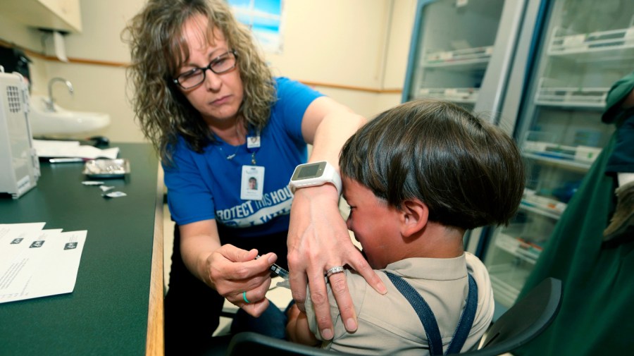 A registered nurse and immunization outreach coordinator with the Knox County Health Department, administers a vaccination to a kid at the facility in Mount Vernon, Ohio, Friday May 17, 2019.