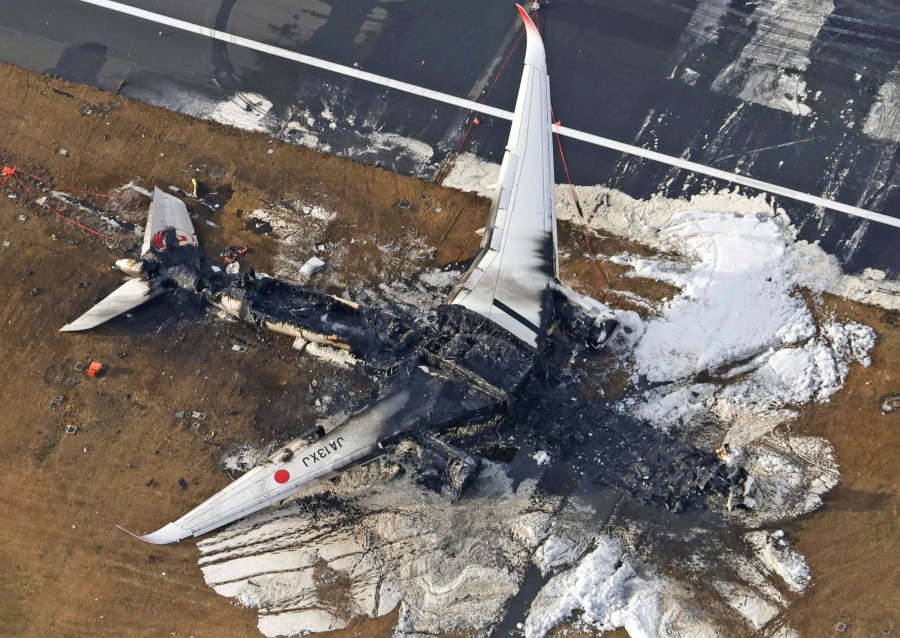 This aerial photo show the burn-out Japan Airlines plane at Haneda airport on Wednesday, Jan. 3, 2024, in Tokyo, Japan. The large passenger plane and a Japanese coast guard aircraft collided on the runway at Tokyo's Haneda Airport on Tuesday and burst into flames, killing several people aboard the coast guard plane, officials said. (Kyodo News via AP)
