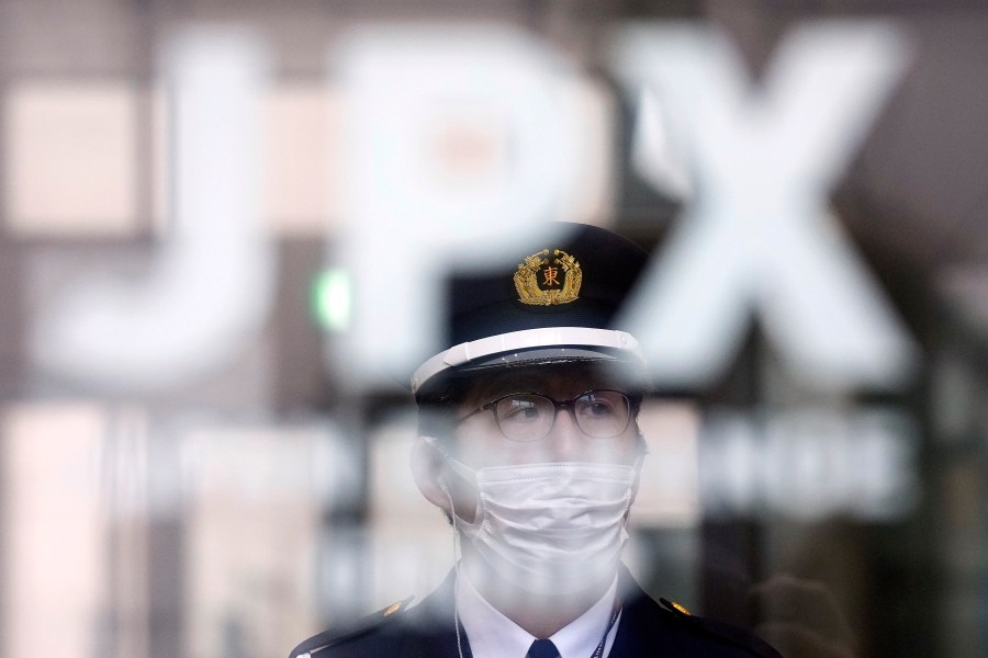 A security guard stands guard at the gate of the Tokyo Stock Exchange Thursday, Jan. 4, 2024, in Tokyo, after a ceremony marking the start of this year's trading. Asian stocks plunged Thursday, echoing the pessimism on Wall Street as the Tokyo exchange marked the first day of trading for the year with a broad slide. (AP Photo/Eugene Hoshiko)