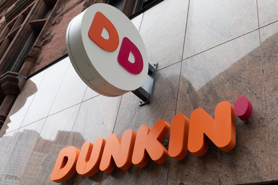 File - The Dunkin' logo is seen on a storefront, Friday, Oct. 14, 2022, in Boston. A customer in central Florida has filed a negligence lawsuit against Dunkin', claiming he was injured from an exploding toilet at one of the coffee chain's locations. (AP Photo/Michael Dwyer, File)