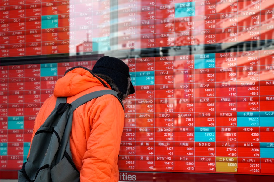 FILE - A person looks at an electronic stock board showing Japan's stock prices at a securities firm on Dec. 20, 2023, in Tokyo. Asian shares were mixed on Friday, Jan. 5, 2024, mirroring the finish on Wall Street, although export-related Tokyo stocks got a boost from a strengthening dollar. (AP Photo/Eugene Hoshiko, File)