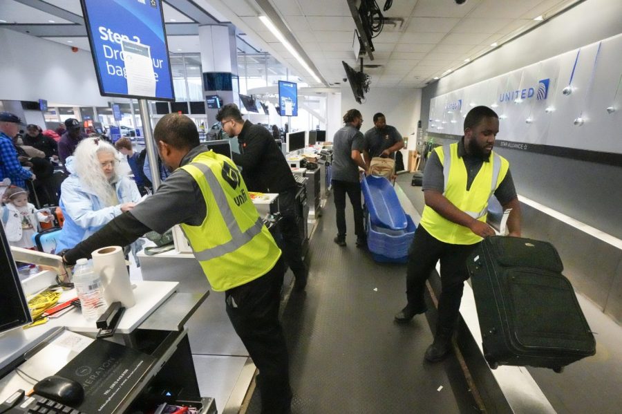 File - Agents check-in passengers and their baggage at George Bush Intercontinental Airport on Dec. 21, 2023, in Houston. On Friday, the U.S. government issues its December jobs report. (Brett Coomer/Houston Chronicle via AP, File)