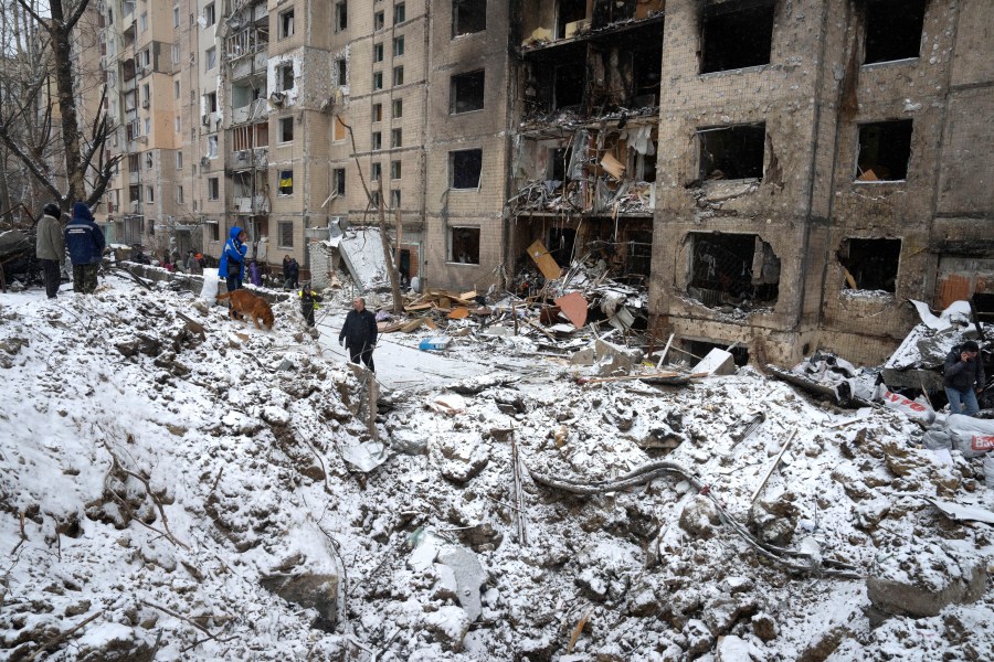 A crater of an explosion is seen next to an apartment building destroyed after Tuesday's Russian attack in Kyiv, Ukraine, Wednesday, Jan. 3, 2024. (AP Photo/Efrem Lukatsky)