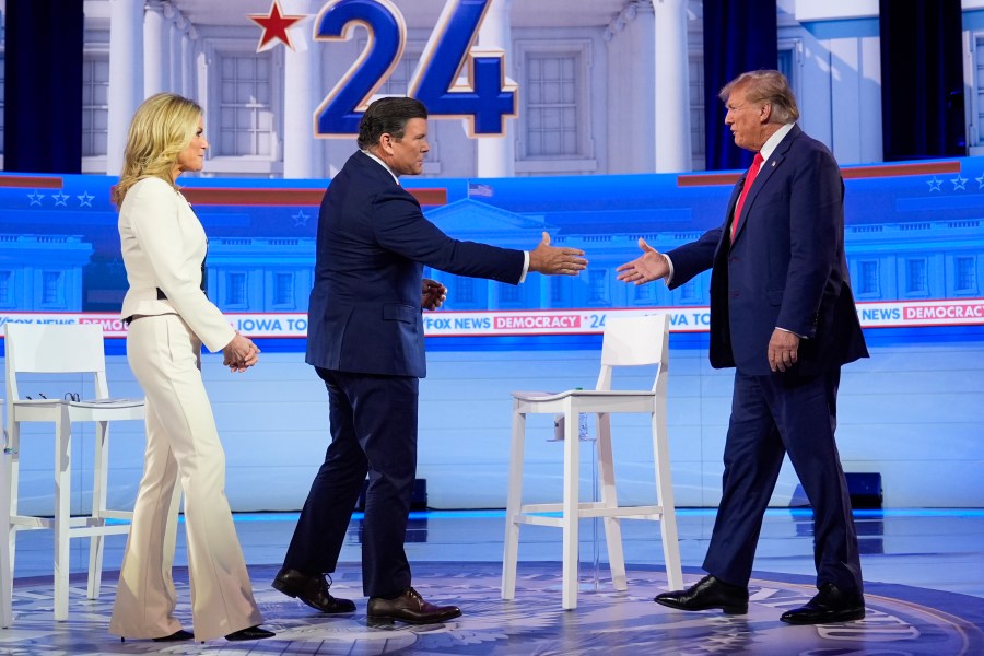 Republican presidential candidate former President Donald Trump greets moderators Martha MacCallum and Bret Baier as he arrives on stage for a Fox News Channel town hall in Des Moines, Iowa, Wednesday, Jan. 10, 2024. (AP Photo/Carolyn Kaster)