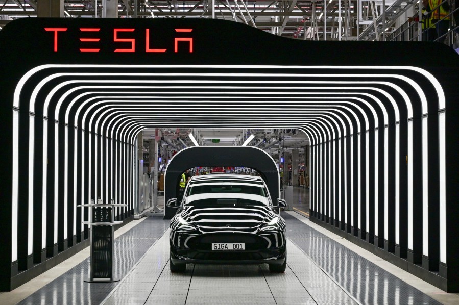 Tesla's Model Y electric vehicles are seen on a factory conveyor belt.