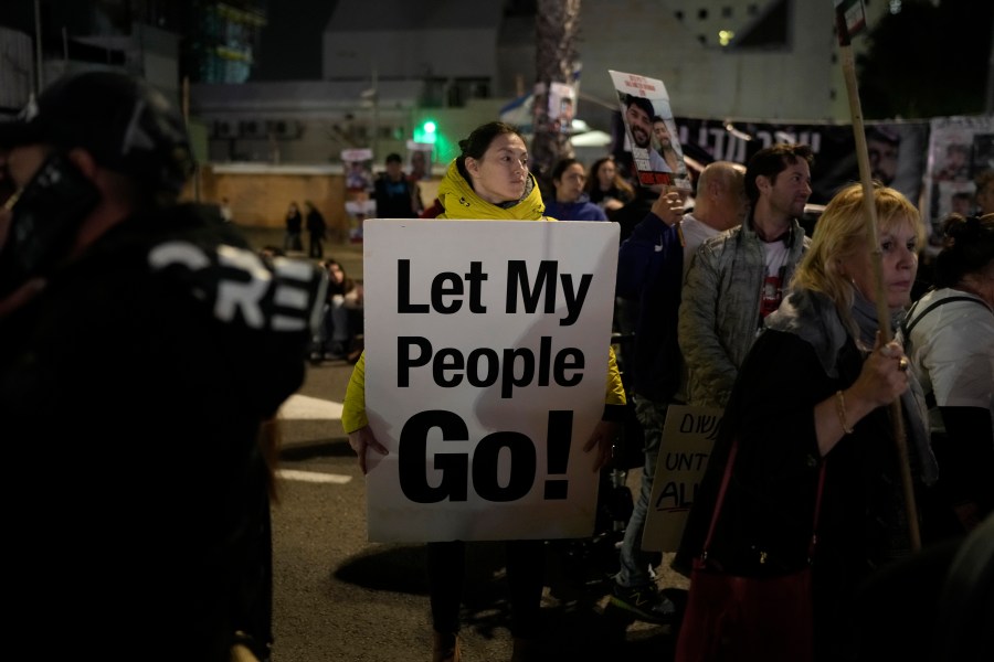 A woman holds a sign calling for the release of the hostages taken by Hamas militants into the Gaza Strip at the Hostages Square in Tel Aviv, Israel, Saturday Jan. 13, 2024. Sunday marks 100 days that Israel and Hamas have been at war after Hamas' cross-border attack on Oct. 7 in which the group killed some 1,200 people, mostly civilians, and took 250 others hostage. In the Gaza Strip, health authorities say the death toll already has eclipsed 23,000 people, roughly 1% of the Palestinian territory's population. Thousands more remain missing or badly wounded.