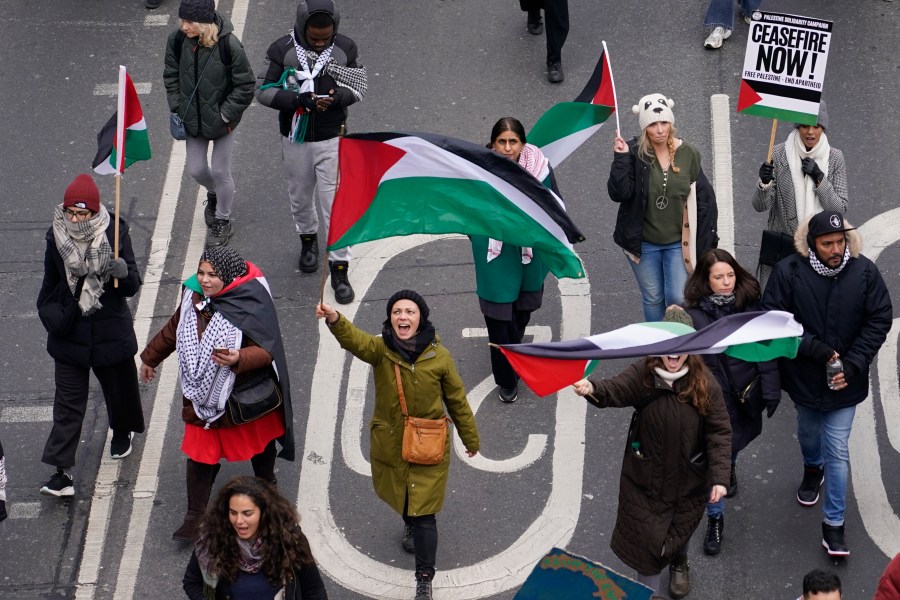 Protesters hold up banners, flags and placards as they walk along the embankment by the River Thames during a demonstration in support of Palestinian people in Gaza, in London, Saturday, Jan. 13, 2024.(AP Photo/Alberto Pezzali)