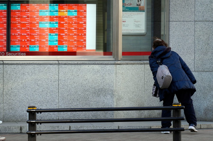 FILE - A person looks at an electronic stock board showing Japan's Nikkei 225 index at a securities firm in Tokyo, on Jan. 17, 2024. Asian shares traded mixed Thursday, Jan. 18, 2024 as pessimism spread among investors about any imminent interest rate cut in the United States. (AP Photo/Eugene Hoshiko, File)