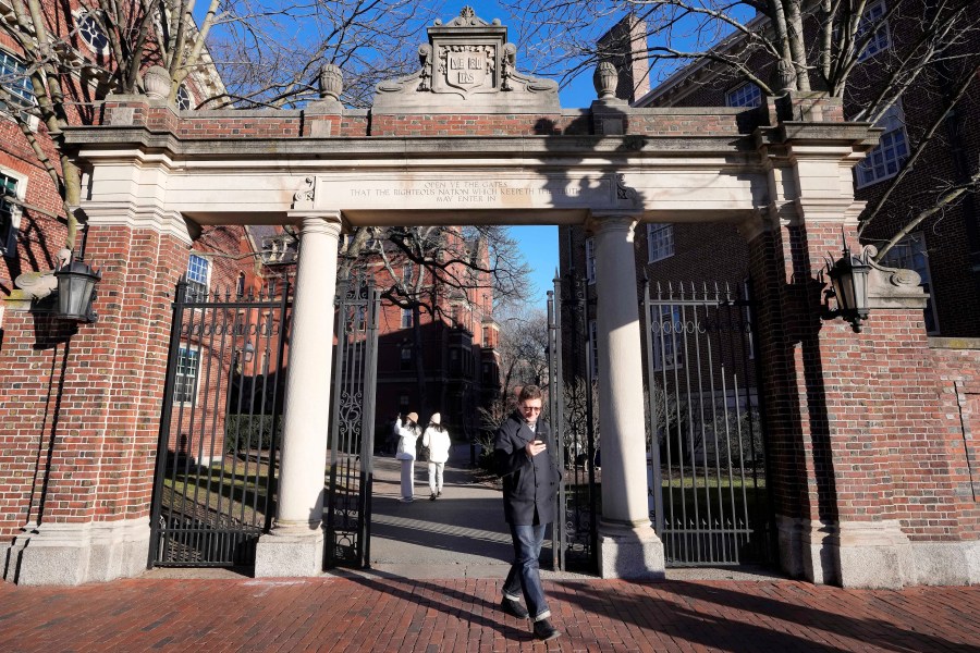 FILE - A passer-by walks through a gate to the Harvard University campus, Tuesday, Jan. 2, 2024, in Cambridge, Mass. Harvard University, struggling to manage the campus response to the Israel-Hamas war, announced plans Friday, Jan. 19, to create task forces to combat antisemitism and anti-Arab bias. (AP Photo/Steven Senne)