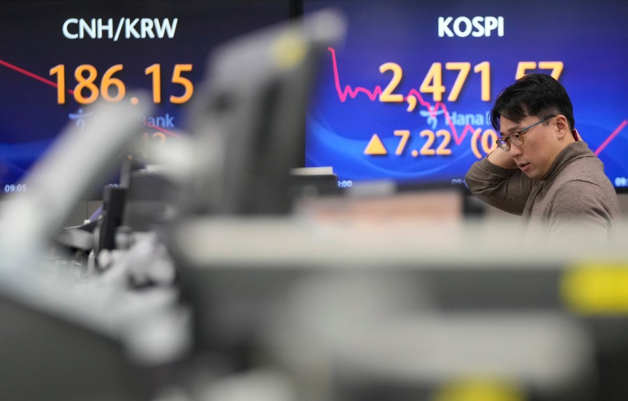 A currency trader watches monitors near the screens showing the Korea Composite Stock Price Index (KOSPI), right, at the foreign exchange dealing room of the KEB Hana Bank headquarters in Seoul, South Korea, Tuesday, Jan. 23, 2024. Asian shares mostly rose Tuesday after Wall Street built on its all-time high reached last week, while Japan’s central bank kept its easy credit policy intact. (AP Photo/Ahn Young-joon)