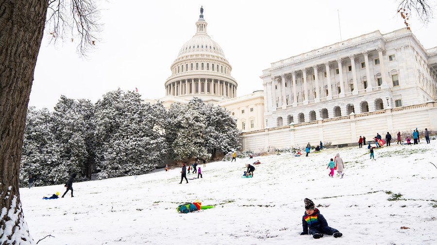 Kids sled down the hill outside the House Chamber at the Capitol in Washington, D.C.