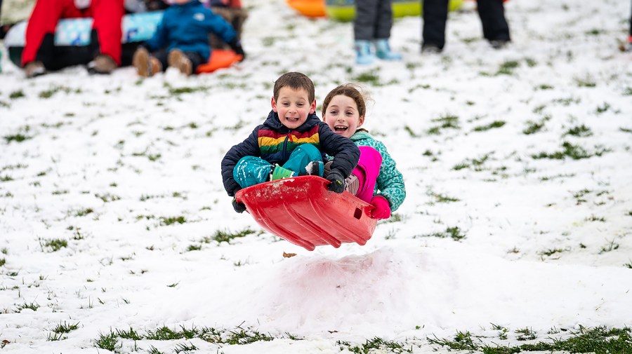 Kids sled down the hill outside the House Chamber at the Capitol in Washington, D.C.