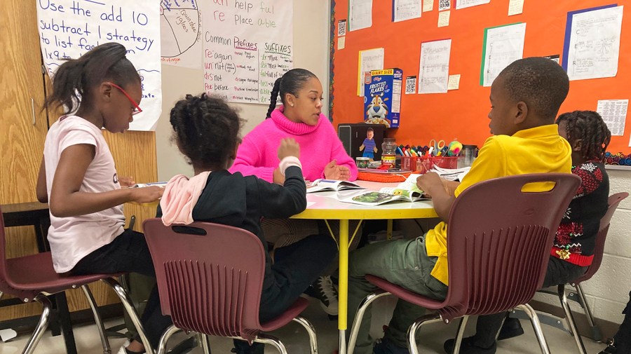 Third-grade teaching assistant Keione Vance leads a reading session with a small group of students at Boyd Elementary School in Atlanta, Dec. 15, 2022.