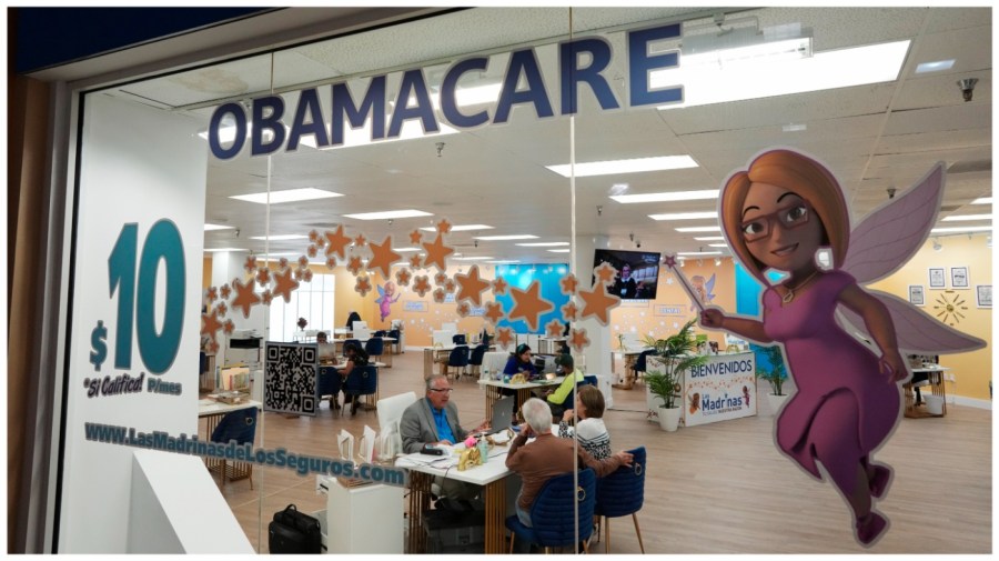 An insurance agent talks with clients at a shopping center.