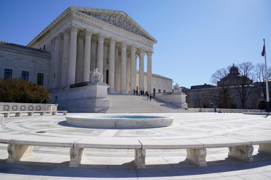 People stand on the steps of the U.S. Supreme Court, Feb.11, 2022, in Washington.