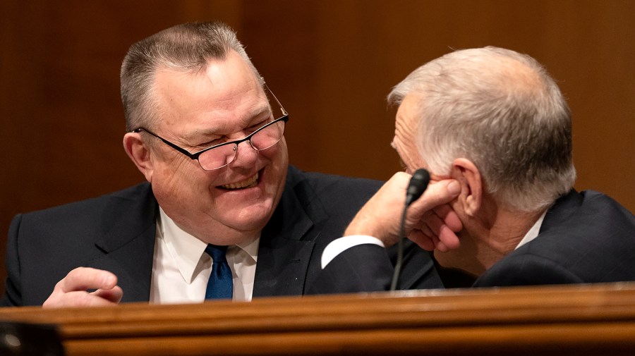 Sen. Jon Tester (D-Mont.) speaks with Sen. Thom Tillis (R-N.C.)