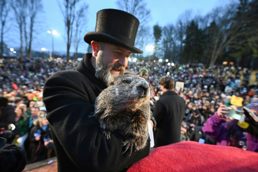 Groundhog Club handler A.J. Dereume holds Punxsutawney Phil, the weather prognosticating groundhog, during the 138th celebration of Groundhog Day on Gobbler's Knob in Punxsutawney, Pa., Friday, Feb. 2, 2024. Phil's handlers said that the groundhog has forecast an early spring. (AP Photo/Barry Reeger)