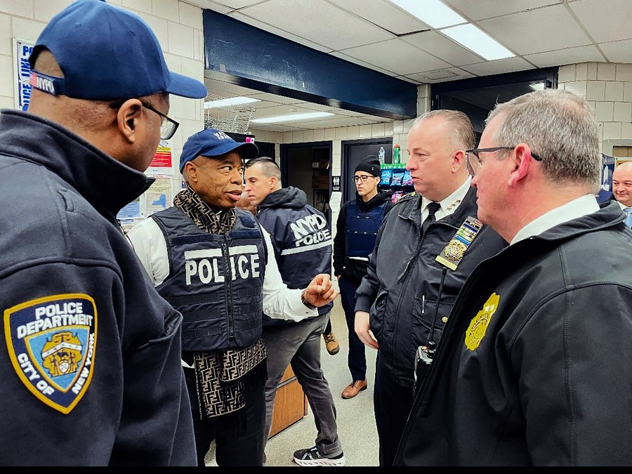 This photo provided by the Office of New York City Police Department Assistant Commissioner Kaz Daughtry, Monday, Feb. 5, 2024, shows New York Mayor Eric Adams, second left, who joined investigators and specialized teams as they carried out a search warrant. The raid, in the Bronx borough of New York, targeting suspects in a cell phone theft ring came as Adams and police officials have been promising a crackdown on crimes committed by migrants, following a brawl between migrants and police officers in Times Square. (Office of New York City Police Department Assistant Commissioner Kaz Daughtry via AP)