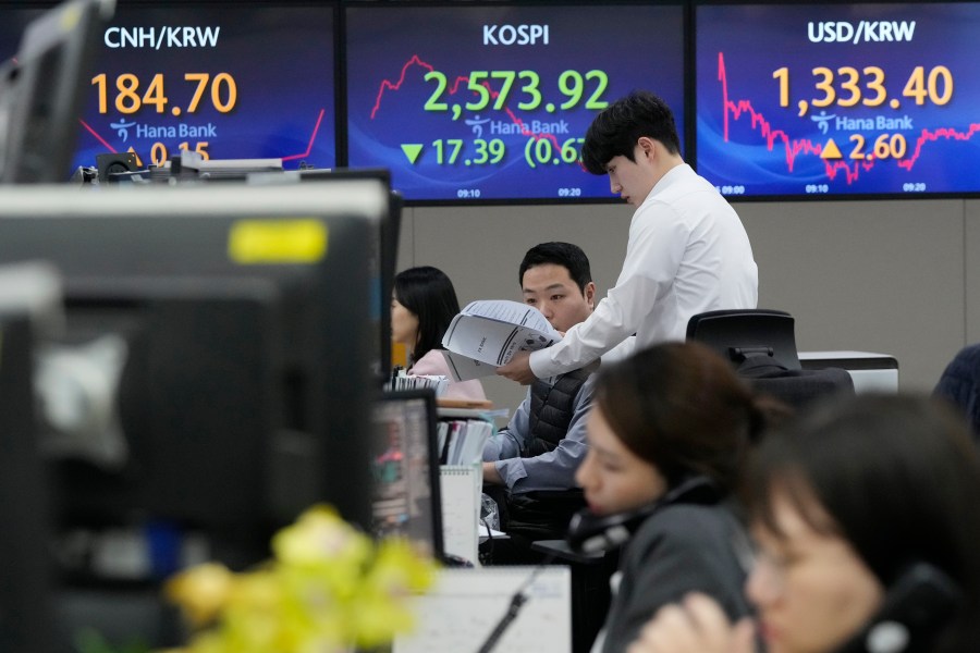 Currency traders work near the screens showing the Korea Composite Stock Price Index (KOSPI), center, and the foreign exchange rate between U.S. dollar and South Korean won, right, at the foreign exchange dealing room of the KEB Hana Bank headquarters in Seoul, South Korea, Tuesday, Feb. 6, 2024. Shares are mixed in Asia, where Chinese markets advanced after a government investment fund said it would step up stock purchases. (AP Photo/Ahn Young-joon)