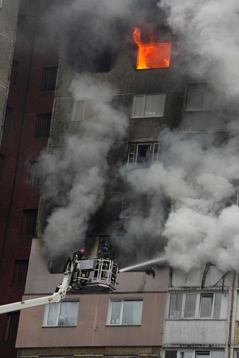 Firefighters work to extinguish a fire in an apartment building after Russian attack in Kyiv, Ukraine, Wednesday, Feb. 7, 2024. Authorities say Russia has fired cruise and ballistic missiles and Shahed-type drones at targets across Ukraine including the capital Kyiv. Officials said the Wednesday morning attack killed at least one civilian and injured 10 others. (AP Photo/Efrem Lukatsky)