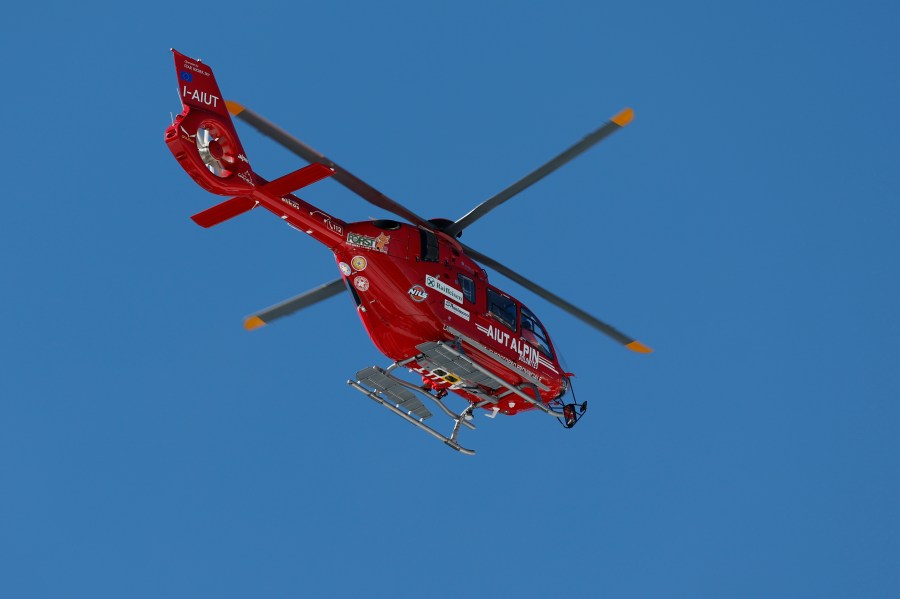 A helicopter flies evacuating United States' Mikaela Shiffrin after she crashed during an alpine ski, women's World Cup downhill race, in Cortina d'Ampezzo, Italy, Friday, Jan. 26, 2024. Shiffrin crashed into the safety nets after losing control landing a jump during a World Cup women's downhill on Friday. (AP Photo/Alessandro Trovati)