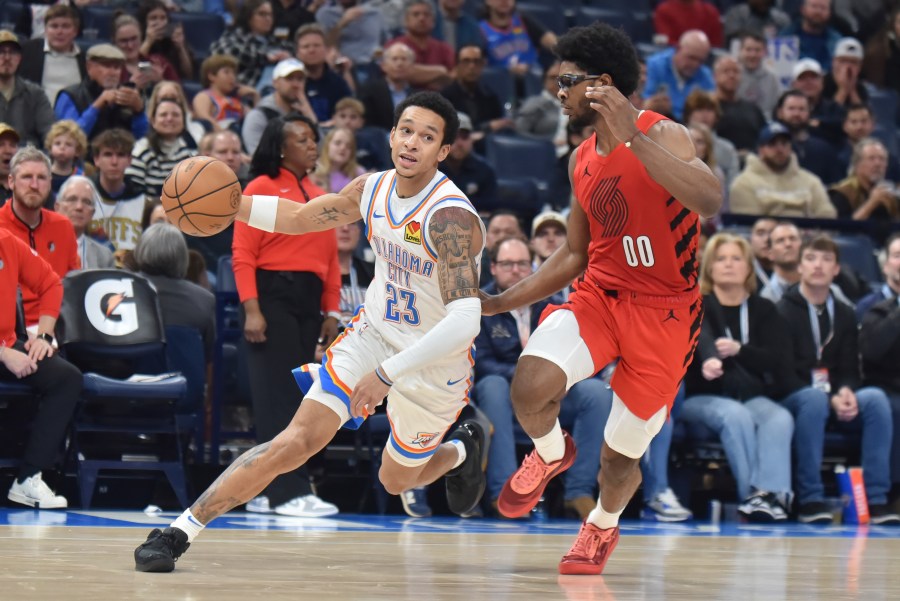 Oklahoma City Thunder guard Tre Mann (23) drives past Portland Trail Blazers guard Scoot Henderson (00) during the second half of an NBA basketball game Thursday, Jan. 11, 2024, in Oklahoma City. (AP Photo/Kyle Phillips)