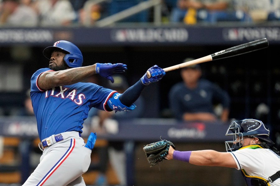 FILE - Texas Rangers' Adolis Garcia, left, bats against the Tampa Bay Rays during Game 1 in an AL wild-card baseball playoff series Oct. 3, 2023, in St. Petersburg, Fla. The World Series champion Rangers finalized deals Friday, Jan. 26, 2024, with veteran reliever David Robertson and outfielder Travis Jankowski, but still have no agreement with AL Championship Series MVP García in advance of salary arbitration hearings. (AP Photo/John Raoux, File)