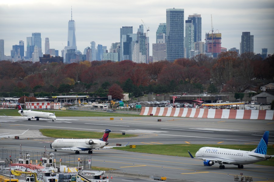 FILE - The New York City skyline is seen behind planes waiting to take off at LaGuardia Airport in New York, Nov. 22, 2023. Most Americans believe that air travel is generally safe in the U.S., despite some doubts about whether aircraft are being properly maintained and remain free from structural problems.(AP Photo/Seth Wenig, File)