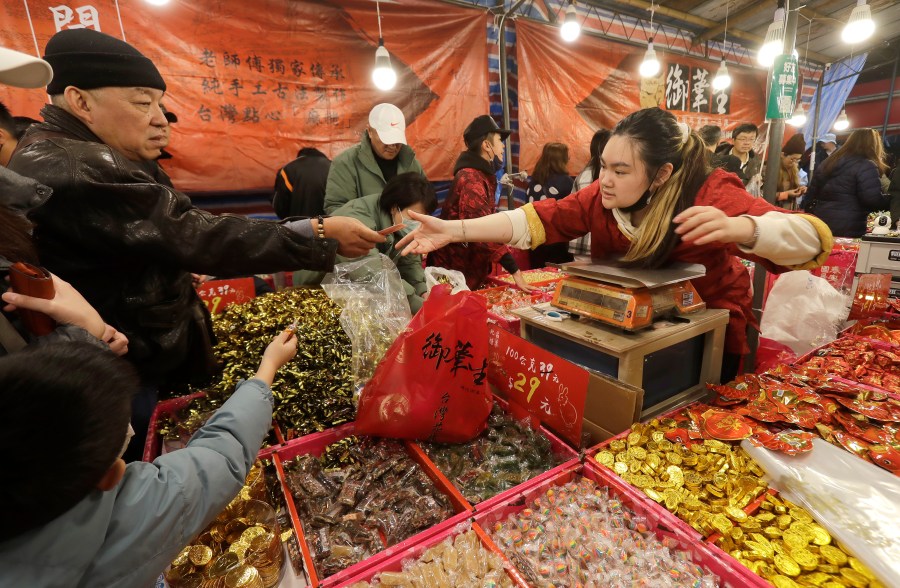 People shop for the upcoming Lunar New Year celebrations at the Dihua street market in Taipei, Taiwan, Thursday, Feb. 8, 2024. Taiwanese shoppers started hunting for delicacies, dried goods and other bargains at the market ahead of the Lunar New Year celebrations which fall on Feb. 10 this year. (AP Photo/Chiang Ying-ying)