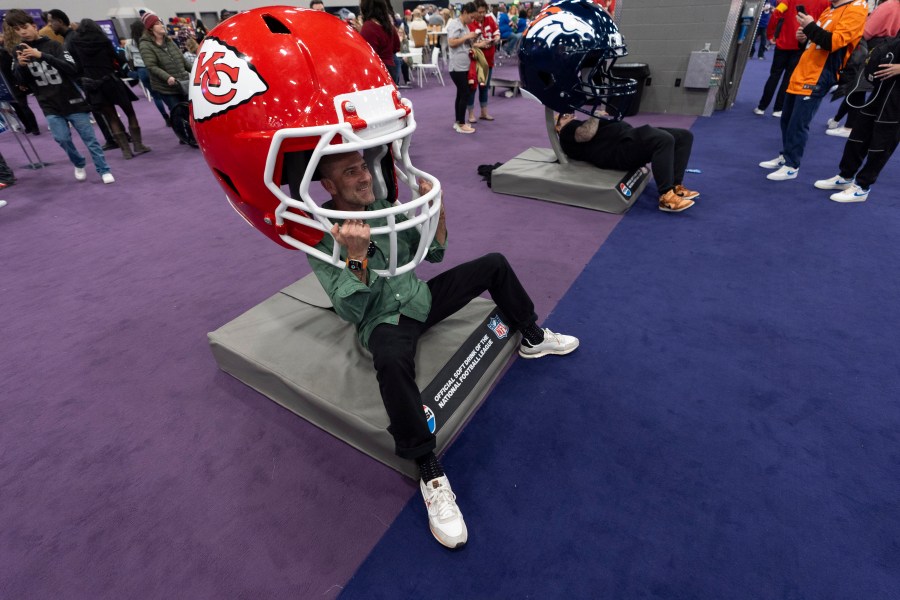 Carlos Morrellon poses with a Kansas City Chiefs helmet during NFL Experience ahead of Super Bowl 58, Saturday, Feb. 10, 2024, in Las Vegas. The Kansas City Chiefs will play the NFL football game against the San Francisco 49ers Sunday. (AP Photo/Gregory Bull)