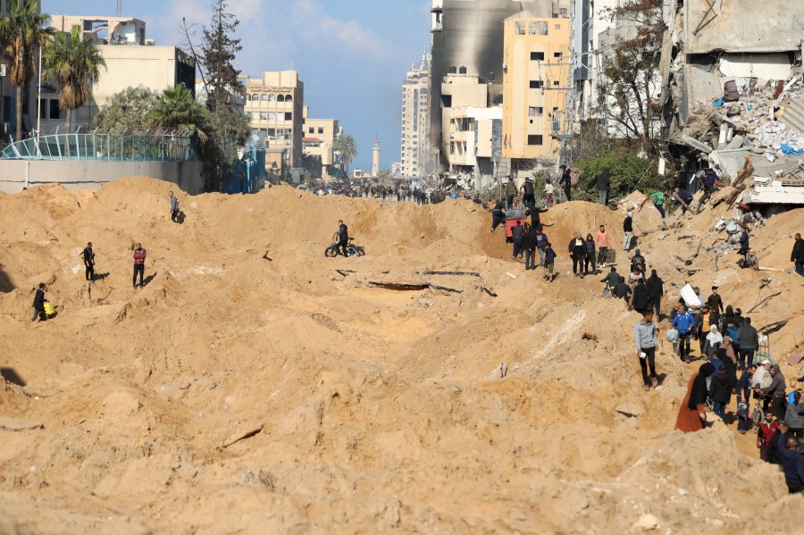 Palestinians walk through the destruction left by the Israeli air and ground offensive on the Gaza Strip in Gaza City, Saturday, Feb. 10, 2024. (AP Photo/Mohammed Hajjar)