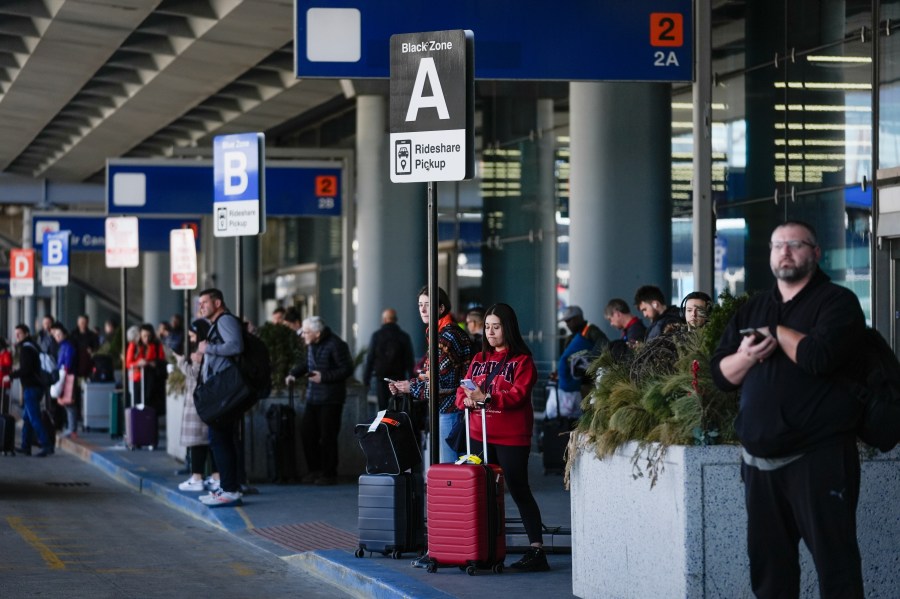 People wait in the rideshare pickup area at O'Hare International Airport, Wednesday, Feb. 14, 2024, in Chicago. Thousands of ride-hailing and delivery workers in the U.S. and the U.K. went on strike on Valentine's Day, calling for higher pay and other changes to their working conditions. (AP Photo/Erin Hooley)