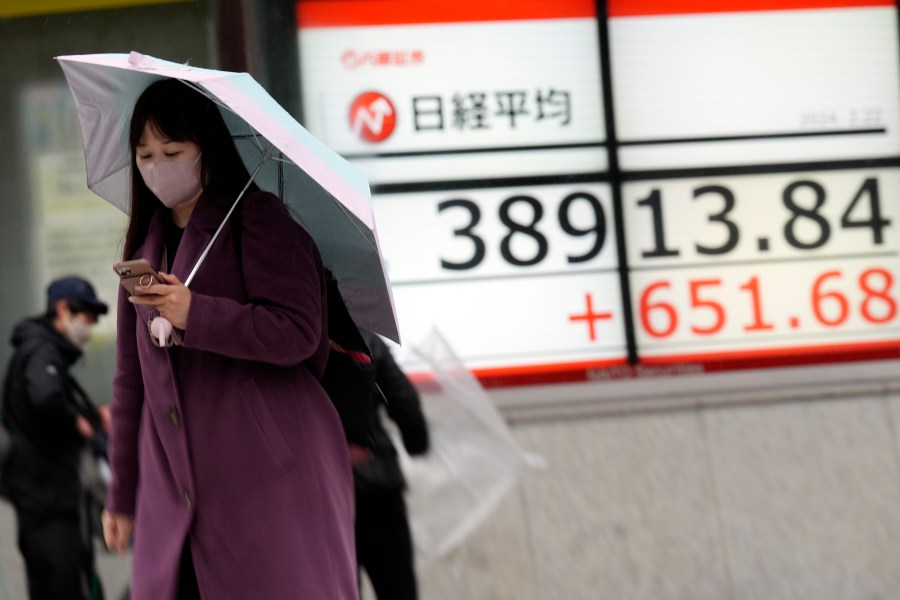 A person walks in front of an electronic stock board showing Japan's Nikkei 225 index at a securities firm Thursday, Feb. 22, 2024, in Tokyo. (AP Photo/Eugene Hoshiko)