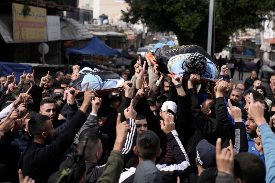 Gunmen carry the bodies of Said Jaradat, left, and Yasser Hanoun, both draped in the flag of the Islamic Jihad militant group, on Friday, Feb. 23, 2024. The pair were killed in an Israeli drone strike on a car in the West Bank Jenin refugee camp a day earlier. The Israeli military alleged that Hanoun was previously involved in several shooting attacks targeting Israeli settlements and army posts. (AP Photo/Majdi Mohammed)