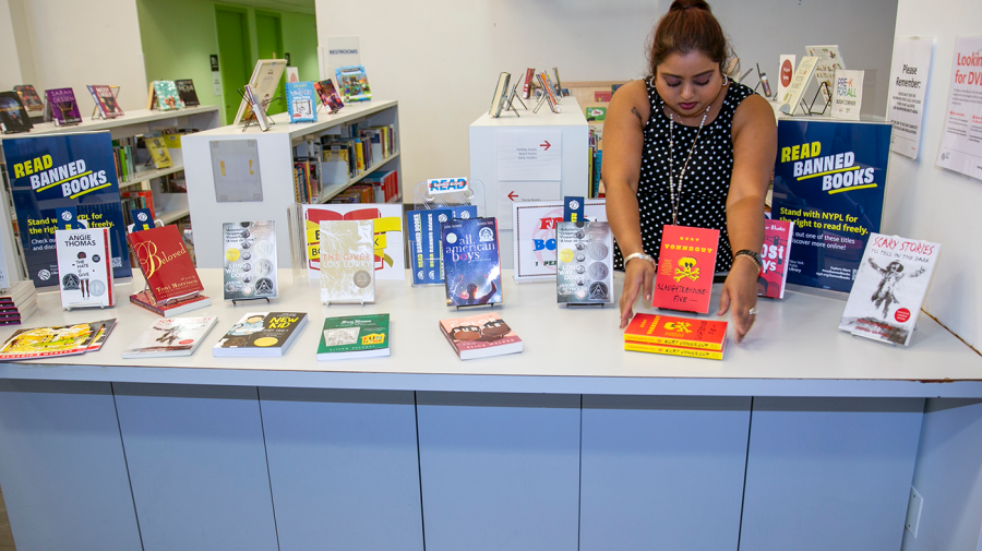 Librarian Sabrina Jesram arranges a display of banned books during Banned Books Week at a New York Public Library branch in New York City.