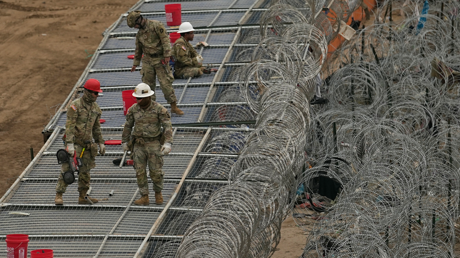 Guardsmen fortify the border along the Rio Grande with concertina wire, Friday, Feb. 2, 2024, in Eagle Pass, Texas.